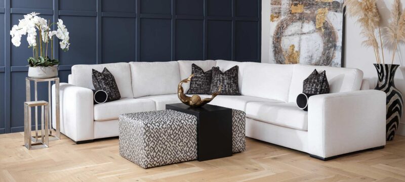 Main corner sofa upholstered in a white fabric with dark grey cushions. 