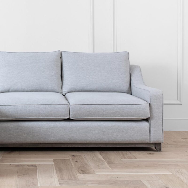 Gatsby sofa in a silver fabric and a grey wash wooden plinth