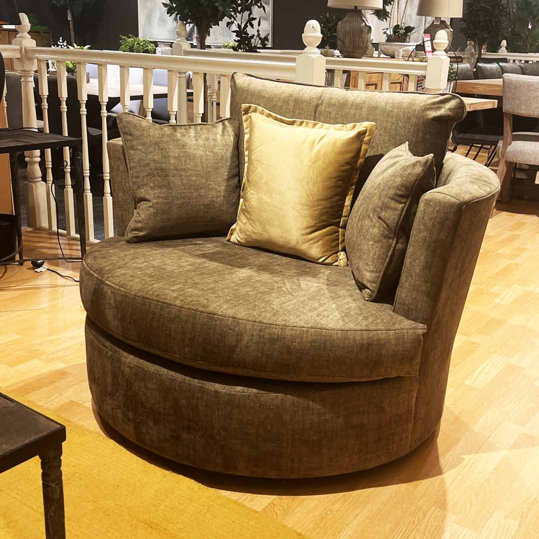 Venice swivel chair in a green velvet fabric with scatter cushions